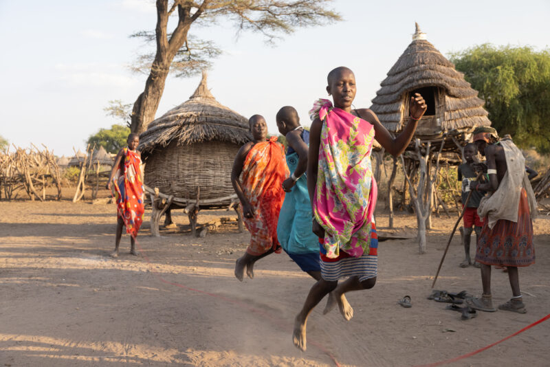 Skipping in Africa — Young girls in South Sudan Africa enjoy skipping in the evening light — Adult, Eyes Closed, Eyes Open, Frontal Face, Male