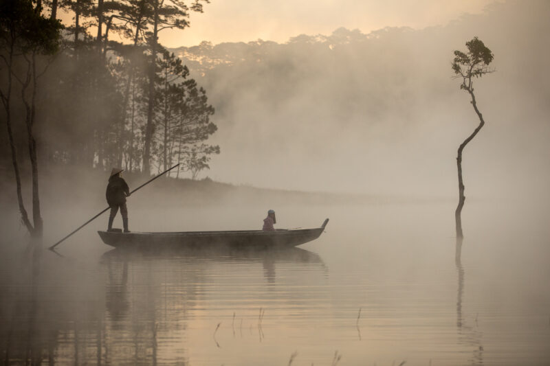 Early Morning on the Lake — Fog and mist rise up from a Lake in Vietnam making a scenic splender with a man in his fishing boat. — Fog, Nature, Person, Unsat...