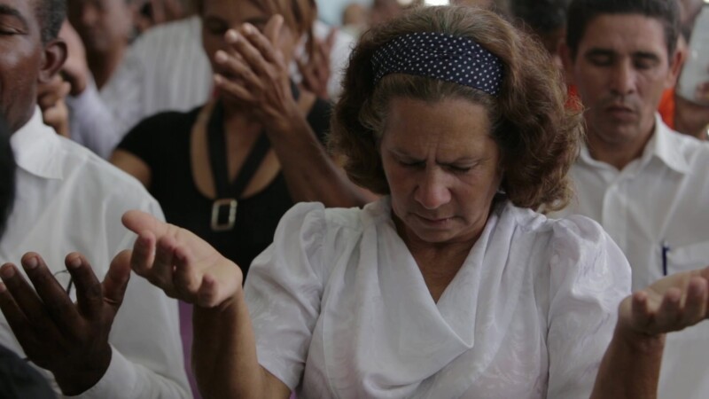 Woman Prays in Church in Cuba — Stock Video Footage of Christianity in Cuba: Woman lifts hands up during a prayer at a Adventist Christian Church service in ...