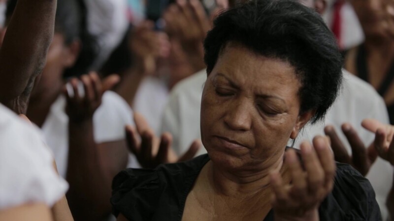Woman Prays in Church in Cuba — Stock Video Footage of Christianity in Cuba: Woman lifts hands up during a prayer at a Adventist Christian Church service in ...