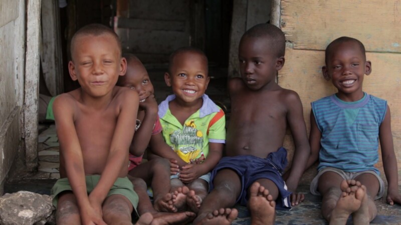 Boys in Doorway — Stock Video Footage of the Dominican Republic: Children living in a poor rural community in the Dominican Republic sit on the step of a hom...