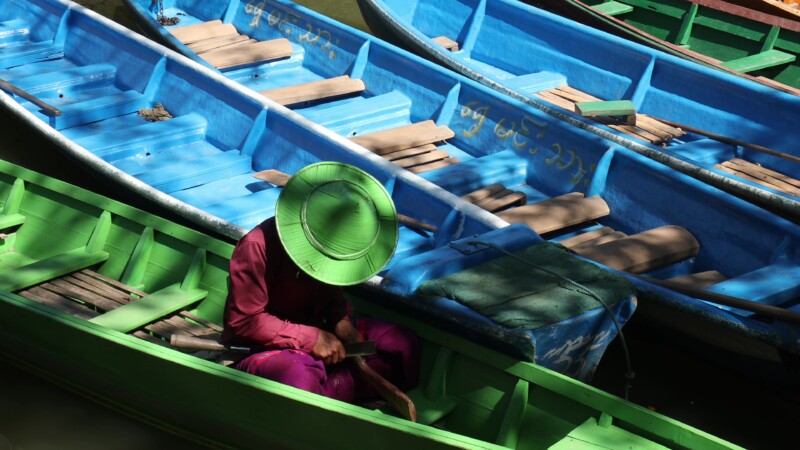 Boatman Works on Carving While Waiting for Customers