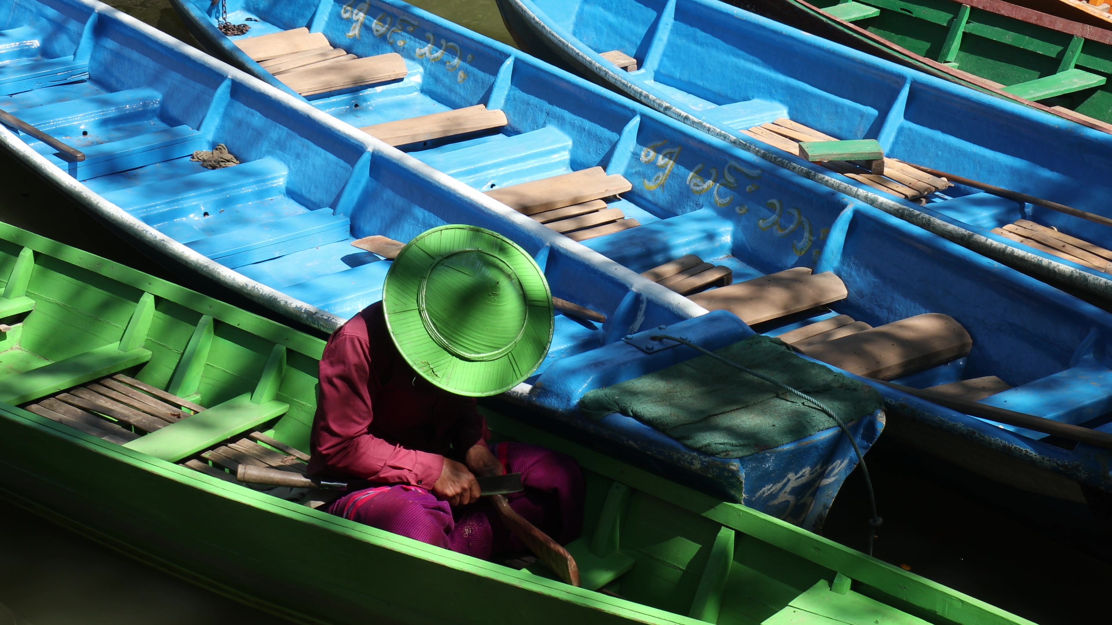 Boatman Works on Carving While Waiting for Customers