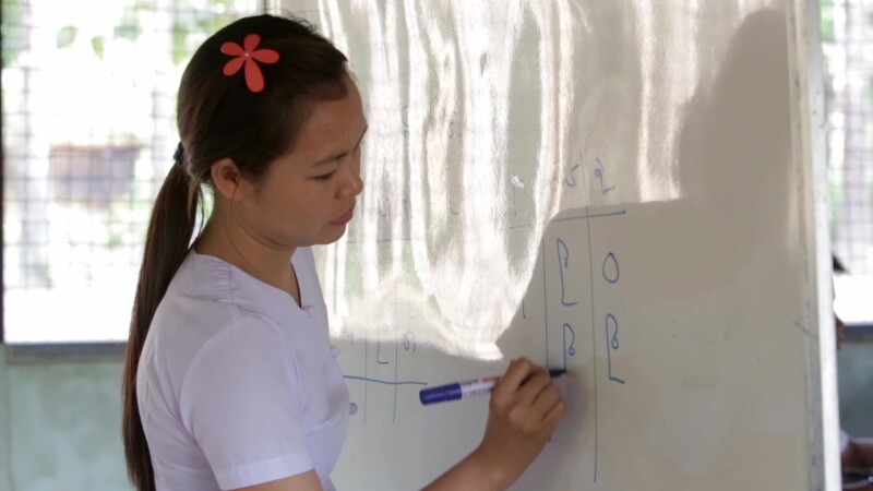 Teacher at a White Board in Myanmar — Teacher writes on a white board at a school in MyanmarKeywords: Burma, Teacher Karen, Karen State, Kayin State, Myanmar...