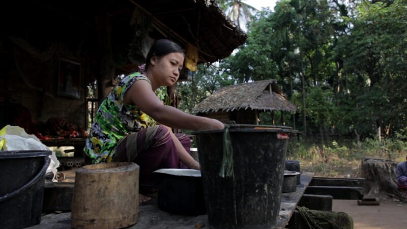 Washing Dishes in Myanmar — Stock Video of Myanmar: Woman living in a remote village in Burma, scrubs pots on the porch of her bamboo home. — Burma, Karen, K...