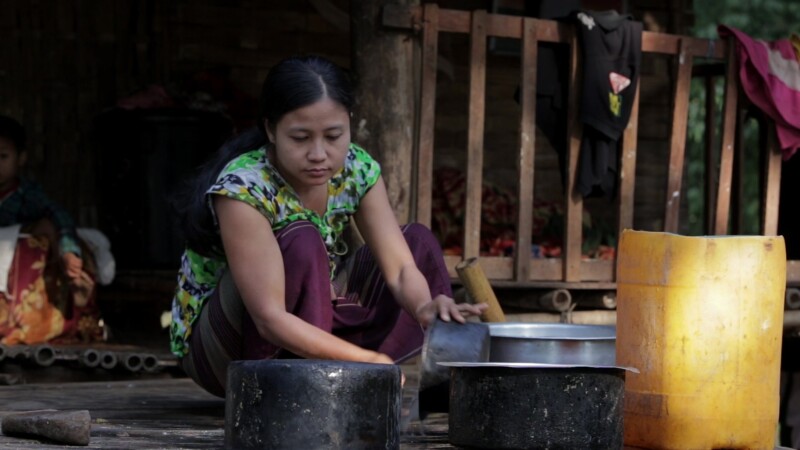 Washing Dishes in Myanmar — Stock Video of Myanmar: Woman living in a remote village in Burma, scrubs pots on the porch of her bamboo home. — Burma, Karen, K...