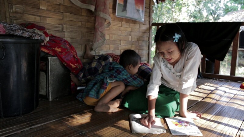 Doing Homework in Rural Myanmar — Young girls does homework on the front porch of her Bamboo home in MyanmarKeywords: Burma, Karen, Karen State, Myanmar, jun...