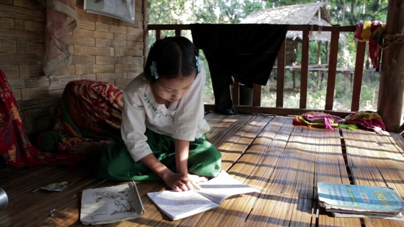 Doing Homework in Rural Myanmar — Young girls does homework on the front porch of her Bamboo home in MyanmarKeywords: Burma, Karen, Karen State, Myanmar, jun...
