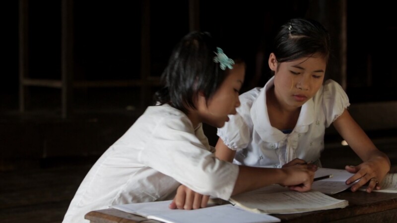 Two Young Girls Work at their Desk — Two Karen girls write at their desk at a temporary school in a remote village in MyanmarKeywords: Burma, Child, Children...