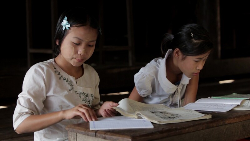 Two Young Girls Work at their Desk — Two Karen girls write at their desk at a temporary school in a remote village in Myanmar — Burma, Child, Children, Karen...