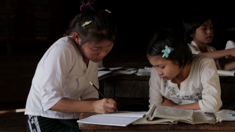 Myanmar 2014 1941151 V1 0097 — Student in the Karen State of Myanmar works on a problem at her desk with her teacher's help. — Burma, Child, Children, Karen,...