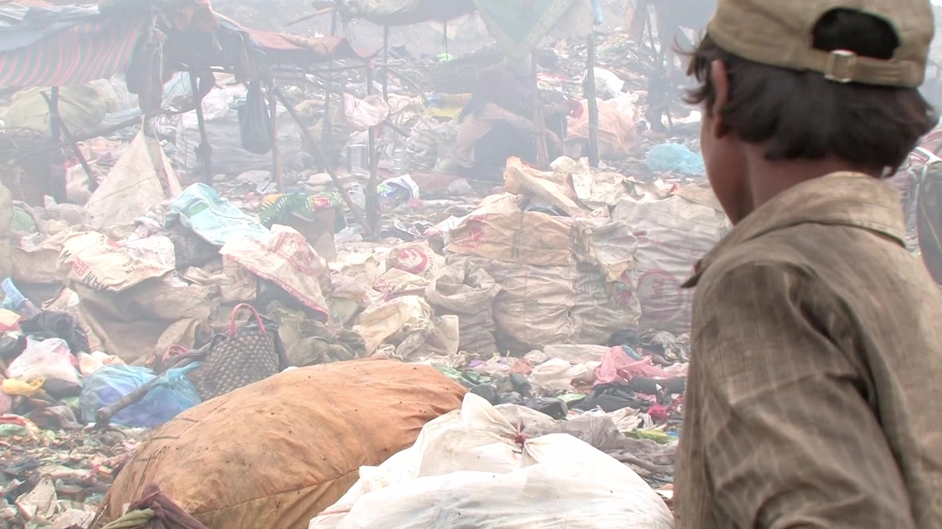 Young Boy works at a City Dump,