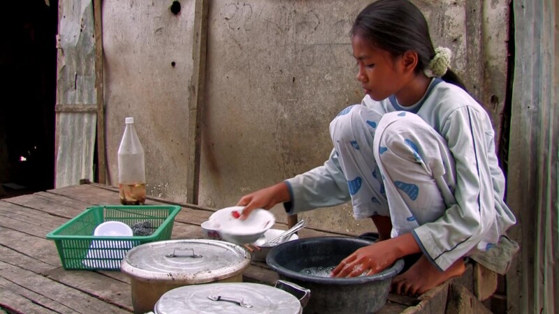 Washing Dishes — Girl in Cambodia washes dishes