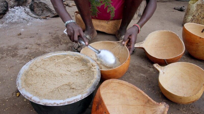 Dishing Up — Girl in Africa dishes up the morning meal into bowls made from gourds. — Africa, South Sudan, Rural, Remote, Pastoralists