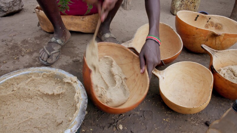 Dishing Up — Girl in Africa dishes up the morning meal into bowls made from gourds. — Africa, South Sudan, Rural, Remote, Pastoralists