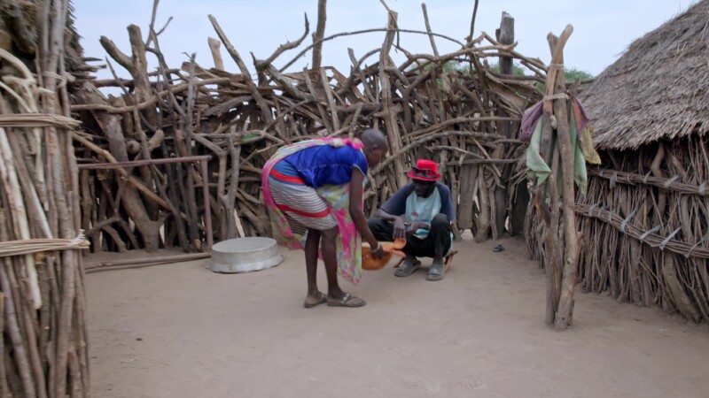 Father is Served — Girl in Africa takes the first bowl of food to her fatherKeywords: Africa, South Sudan, Rural, Remote, Pastoralists, Eastern Equatorial Gu...