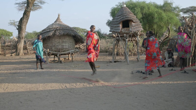 Skipping in Africa — Girls in Africa skip in the evening light. — Africa, South Sudan, Rural, Remote, Pastoralists