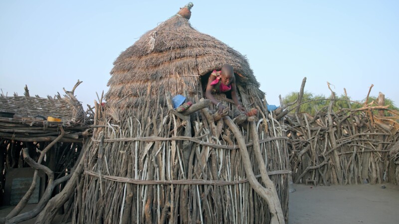 Elevated Bedroom for Girls — Young girls in Africa demonstrate the difficulty of getting in and out of the elevated room where they sleep — Africa, South Sud...