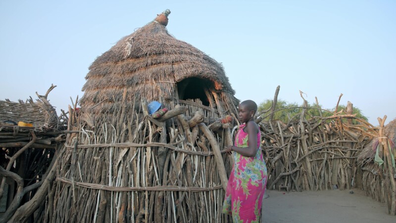Elevated Bedroom for Girls — Young girls in Africa demonstrate the difficulty of getting in and out of the elevated room where they sleep — Africa, South Sud...