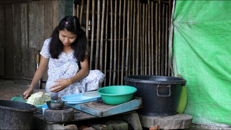 Cooking Food — A young girl in Myanmar cooks dinner for her family in an open kitchen outside her home. — Myanmar, Burma, Burmese, Karen, cooking