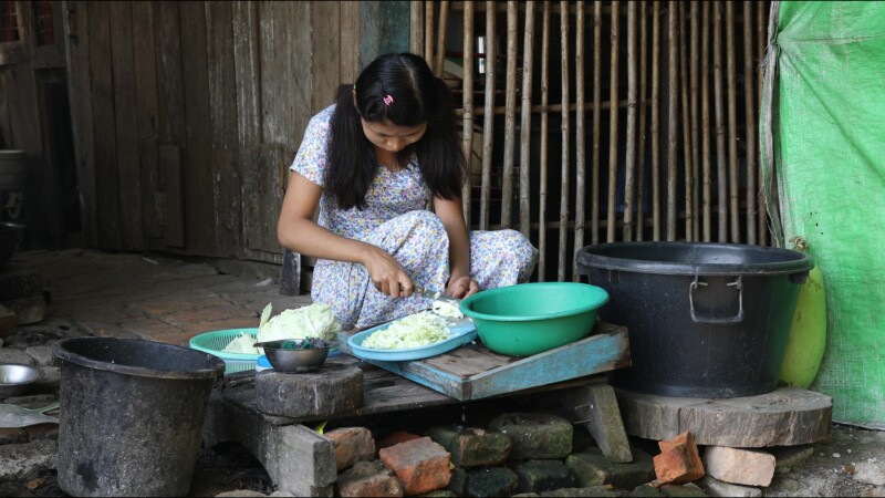 Cooking Food — A young girl in Myanmar cooks dinner for her family in an open kitchen outside her home. — Myanmar, Burma, Burmese, Karen, cooking