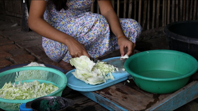 Cooking Food — A young girl in Myanmar cooks dinner for her family in an open kitchen outside her home. — Myanmar, Burma, Burmese, Karen, cooking