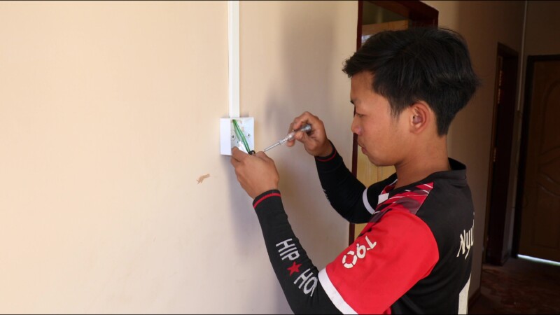 Wireing a House — After getting his certificate from a trade school in Myanmar, run by ADRA, a young many starts his own business wiring homes in his village...