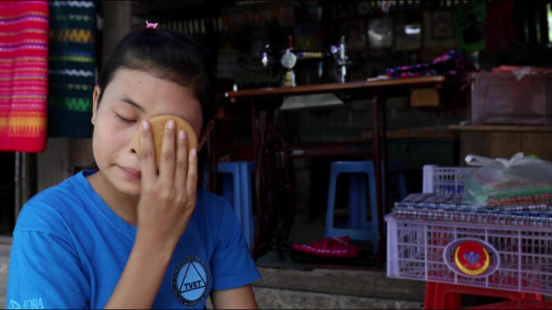 Putting on Thanaka — Young woman in Myanmar puts on thanaka, a skin cream made from the wood of the thanaka tree — Myanmar, Burma, Burmese, Karen, thanaka