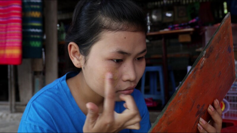 Putting on Thanaka — Young woman in Myanmar puts on thanaka, a skin cream made from the wood of the thanaka tree — Myanmar, Burma, Burmese, Karen, thanaka