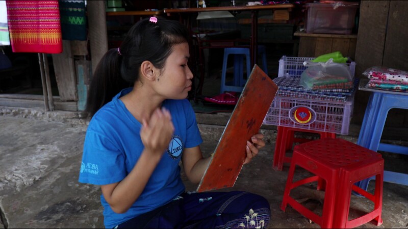 Putting on Thanaka — Young woman in Myanmar puts on thanaka, a skin cream made from the wood of the thanaka tree — Myanmar, Burma, Burmese, Karen, thanaka